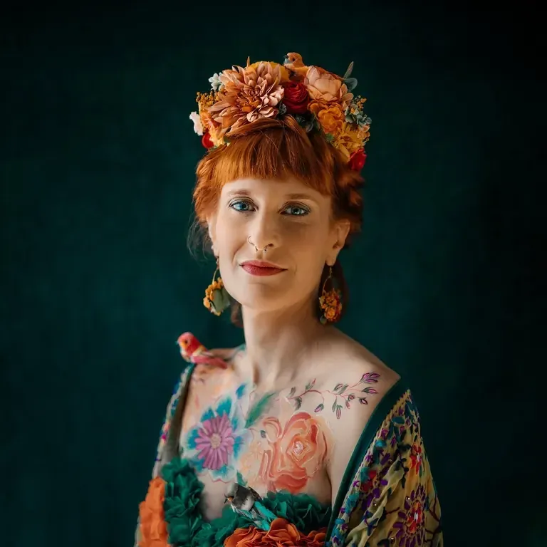 Portrait d’une femme rousse portant une couronne de fleurs, sur fond vert